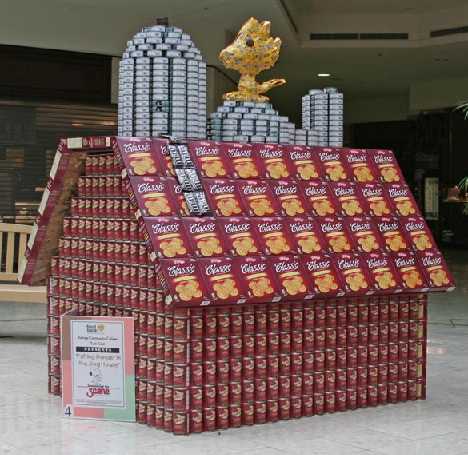 ペットフードの缶詰と箱で作られた、スヌーピーの小屋とウッドストックの店頭ディスプレイ彫刻